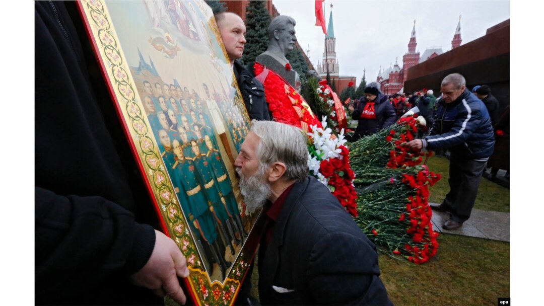 Відзначення дня народження Йосипа Сталіна на його могилі біля Кремлівської стіни на Червоній площі. Чоловік цілує ікону із зображенням радянського диктатора. Москва, 21 грудня 2015 року