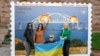 Твір мистецтва у формі великої марки, на якій зображено Кримський міст у вогні. Центр Києва, 8 жовтні 2022 року