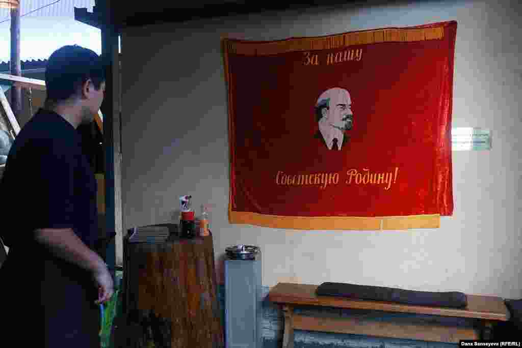 Официант ретро-бара "Целиноград" говорит, что посетители часто фотографируются на фоне флага с изображением Ленина.