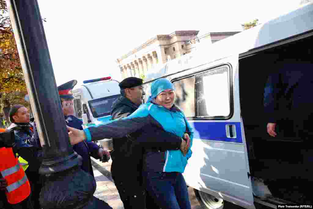  Полицейские задерживают женщину на площади Астана. Алматы. 26 октября 2019 года.