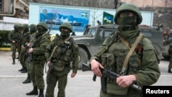 Озброєні особи без розпізнавальних знаків і російський армійський автомобіль біля українського прикордонного поста в місті Балаклаві