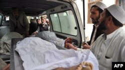 FILE: Volunteers carry a body of a girl killed by a landmine while she collected firewood in the eastern Nangarhar province. 