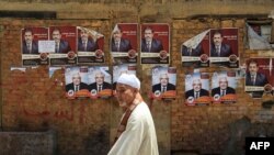 Мужчина идет мимо предвыборных плакатов кандидатов в президенты. Каир, 18 мая 2012 года.