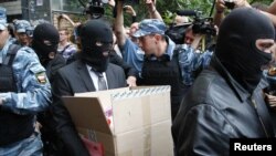 Вооруженные полицейские выносят вещи из квартиры Алексея Навального. Москва, 11 июня 2012 года.