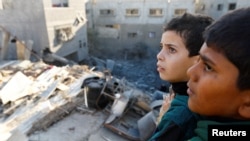 Palestinska djeca gledaju na štetu na mjestu izraelskih udara na kuće, usred tekućeg sukoba između Izraela i Hamasa, u Khan Younisu u južnom pojasu Gaze, 10. decembra 2023.
