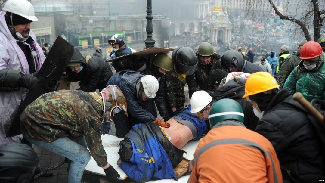 Активісти виносять пораненого товариша під час розстрілу спецпризначенцями людей на Майдані, 20 лютого 2014 року