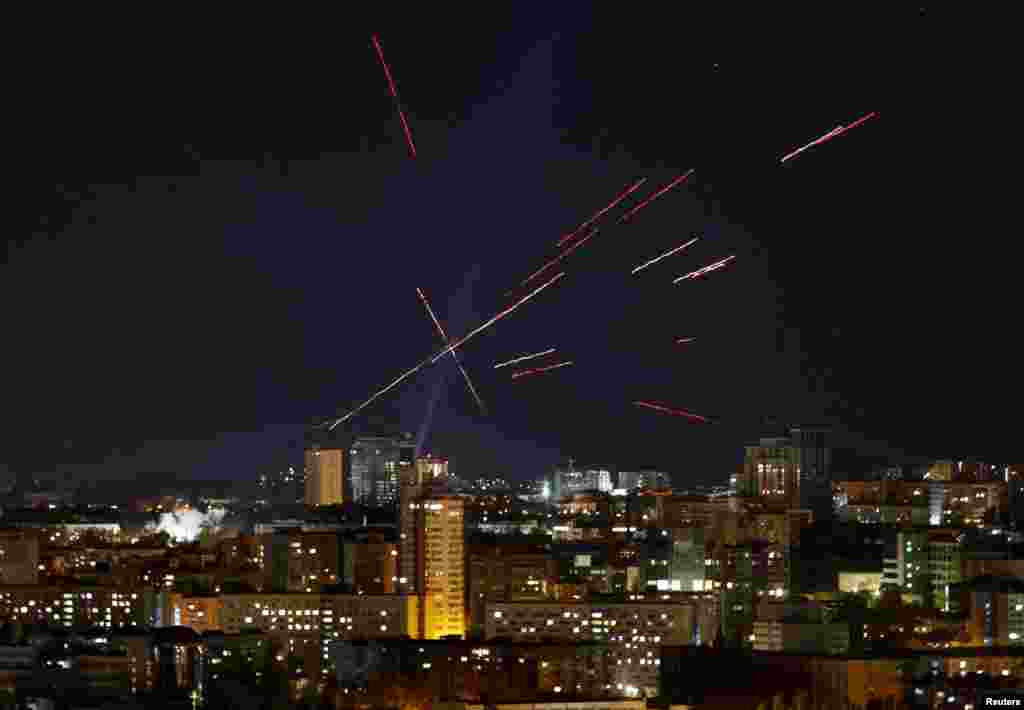 Трассеры и прожекторы видны в ночном небе, когда украинские военнослужащие ищут и стреляют по беспилотнику во время удара российского БПЛА, Киев, Украина, 3 ноября 2024 года. 
