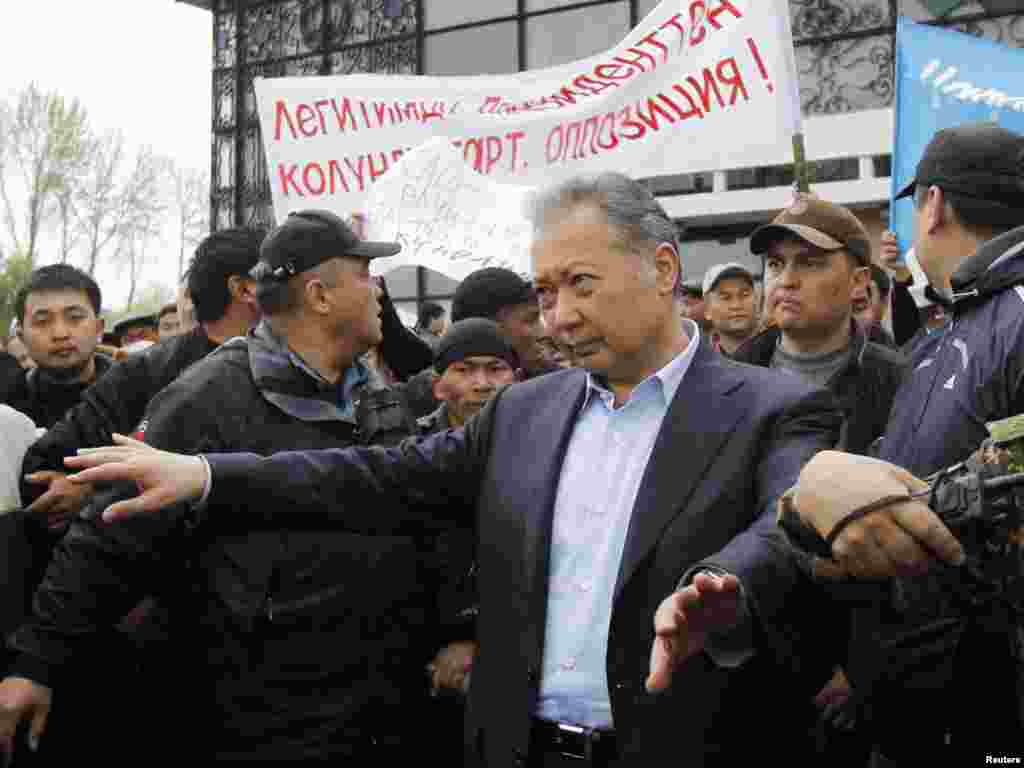 Телохранители помогают Бакиеву покинуть митинг своих сторонников после нападения сторонников Временного правительства. Ош, 15 апреля 2010 года.