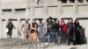 FILE: An Afghan special forces soldier escorts rescued TV journalists after militants attacked Shamshad TV station in Kabul on November 7