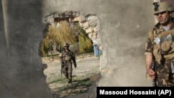 FILE: Afghan soldiers near a hole in a wall made to rescue people from the Shamshad TV building after a deadly attack in Kabul on November 7, 2017.