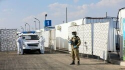 Узбекский военнослужащий у въезда на территорию мобильного госпиталя для пациентов с COVID-19.