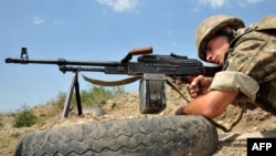Nagorno-Karabakh -- An Armenian soldier of the self-proclaimed republic of Nagorno-Karabagh aims his Kalashnikov machine gun as he stands in a trench at the frontline on the border with Azerbaijan near the town of Martakert, 06Jul2012