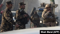 Afghan soldiers block a road near the site of a suicide attack in Kabul on December 25.