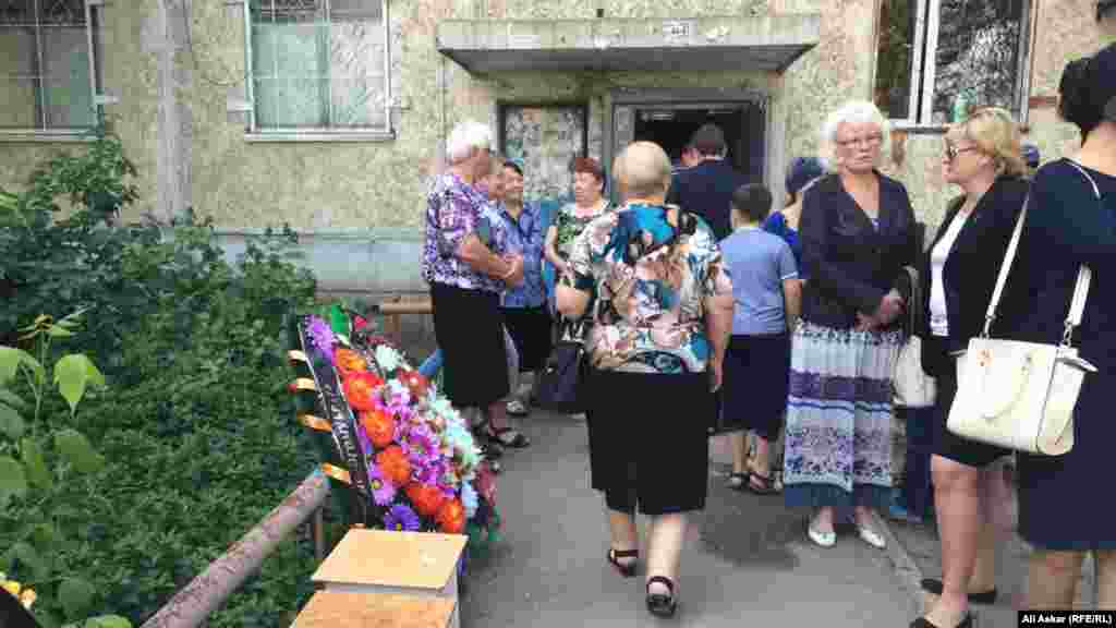 5 маусым күні «Паллада» қару-жарақ дүкені тұсынан өтіп бара жатқанда қаза тапқан тұрғын Николай Онищенкомен қоштасуға келген жұрт. Қару-жарақ дүкені бұл үйдің бірінші қабатына орналасқан. Ақтөбе, 8 маусым 2016 жыл.