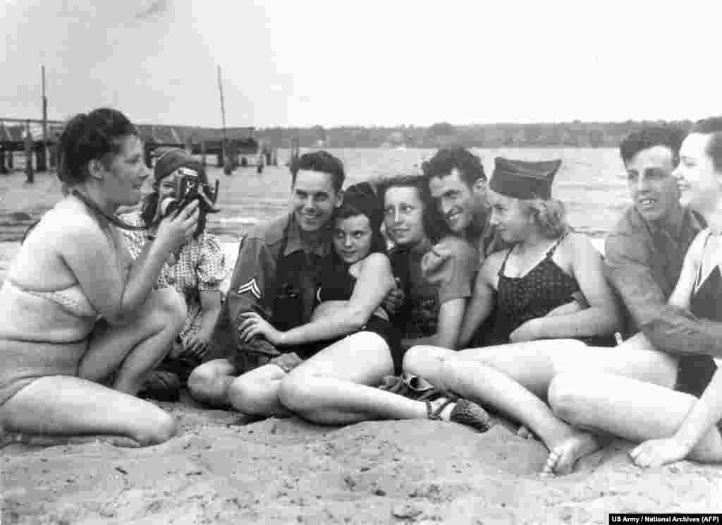 Американски войници с германски момичета на езерото Ванзее през юли 1945 г., малко след като американците пристигат в града. Такова побратимяване с бившите врагове е смятано за скандално, но както една жена отбелязва по това време "първо е храната, а след това моралът."