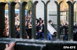 Iranian students clash with riot police during an antigovernment protest around the University of Tehran on December 30.