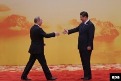 Президент Китая Си Цзиньпин (справа) встречает президента России Владимирa Путина. Пекин, 10 ноября 2014 года.