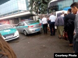 Делегаты регионального Конгресса Свидетелей Иеговы садятся в автобус, рядом – полицейские машины. Фото предоставлено «Христианским Центром Свидетелей Иеговы» в Алматы. 24 июня 2017 года.