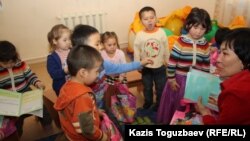Дети рассматривают полученные в мини-центре подарки. Алматы, 14 февраля 2013 года.
