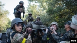 Українські військові несуть пораненого під час бою проти російсько-гібридних сил поблизу міста Іловайська, 10 серпня 2014 року