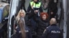 Laura Vicol arată cătușele în timp ce este dusă la Curtea de Apel București, pentru a se judeca cererea de arestare preventivă pe numele ei, 4 februarie 2025.