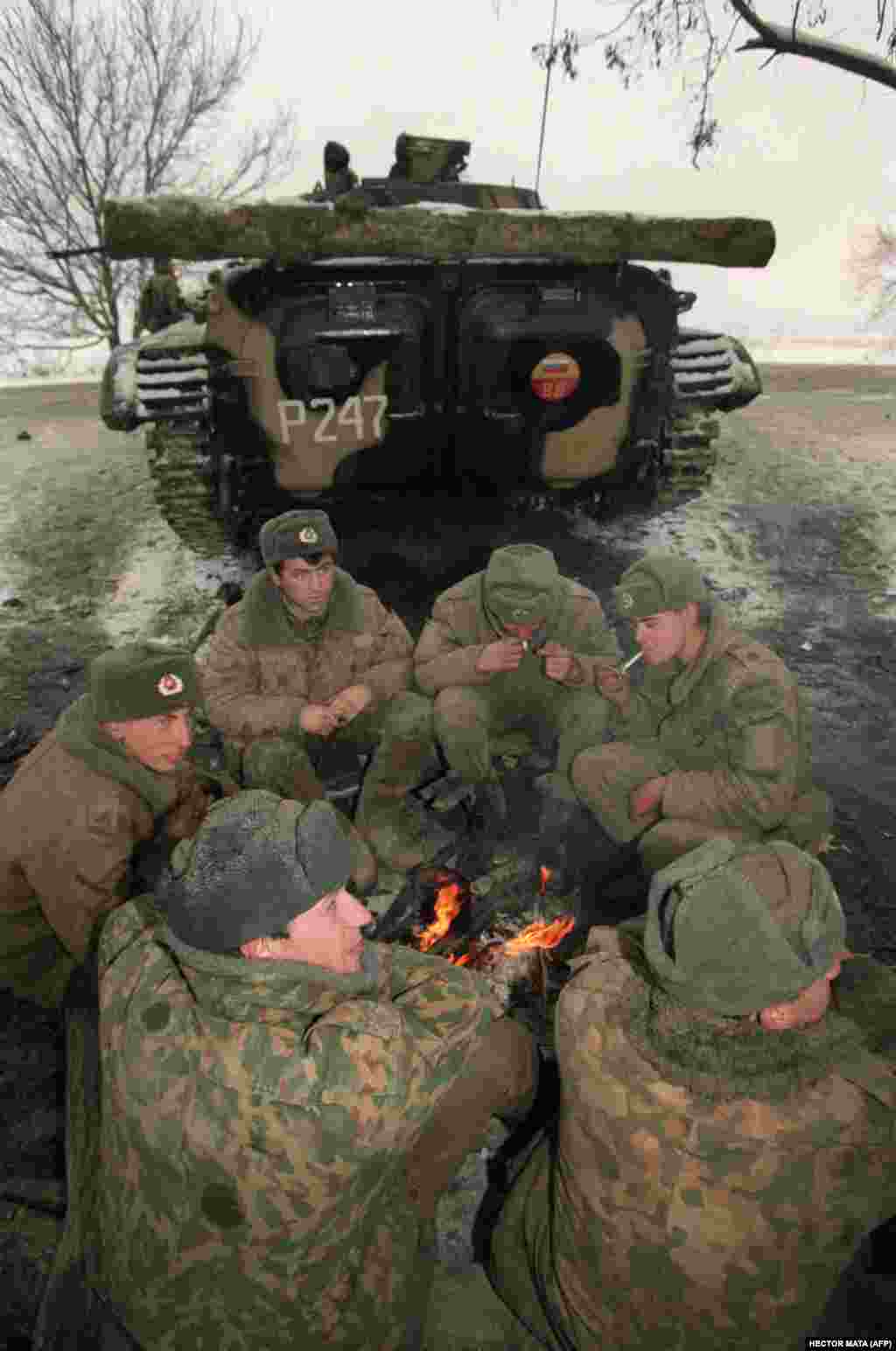 Российские военнослужащие греются у костра в дагестанском Хасавюрте на границе с Чечней, ожидая приказа двинуться на Грозный. 22 декабря 1994 года.