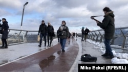 Музика грає на мосту, що його кілька років тому відкрили у Києві. Цей скляний міст є дуже популярним серед киїн та гостей столиці України.