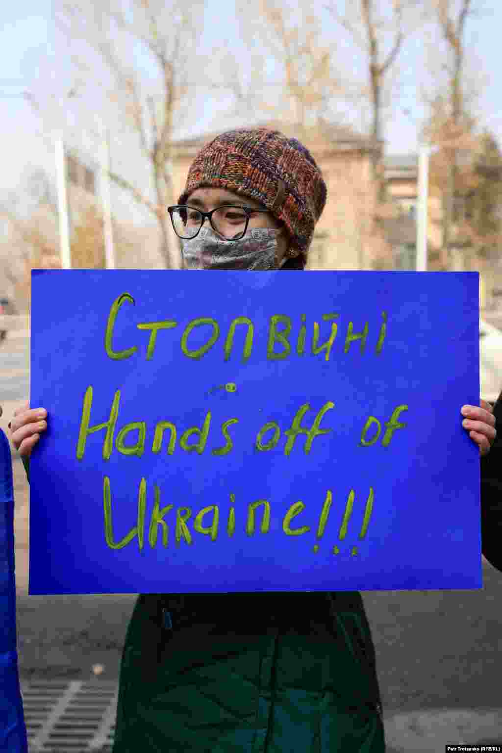 Участница акции у генерального консульства России в Алматы. Надпись на плакате: «Нет войне. Руки прочь от Украины!!!» Власти Украины заявляют о жертвах среди мирного населения