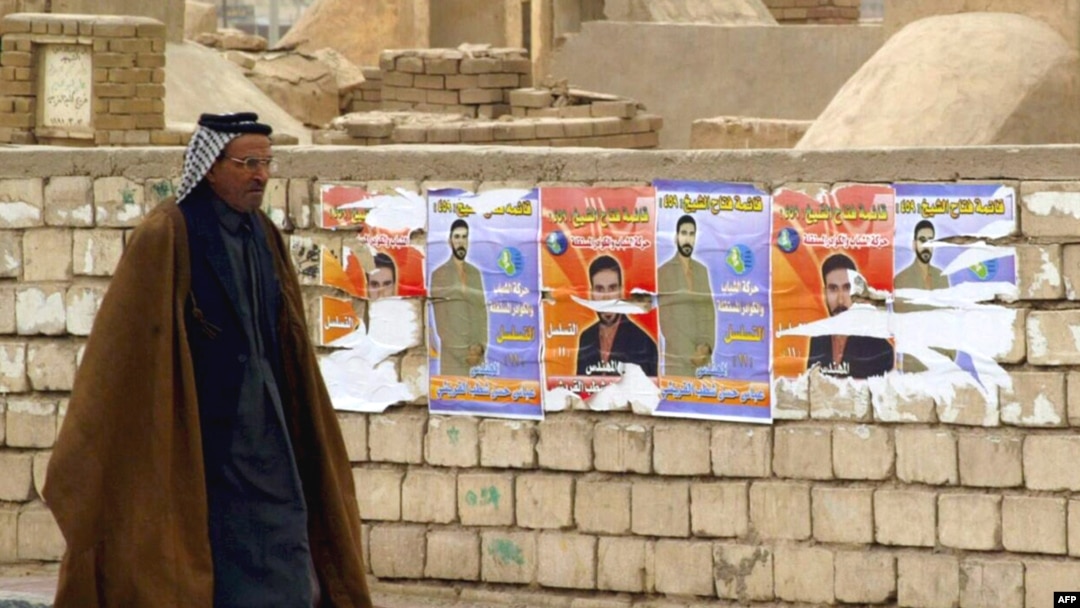 Election posters on a wall at Al-Najaf cemetery in Iraq