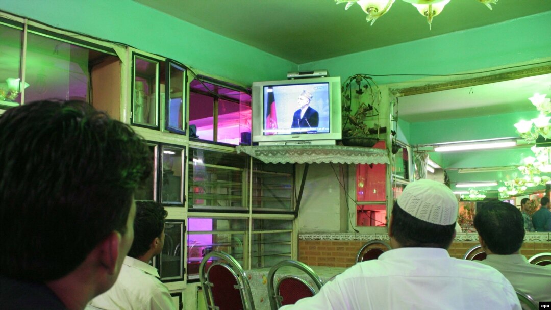 Afghans watch the debate at a shop in Kabul.