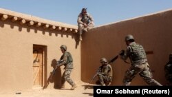 A U.S. Marine watches Afghan soldiers during training in Helmand Province.