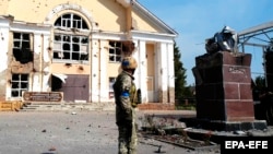 Солдат ВСУ возле разрушенного памятника Ленину в городе Суджа Курской области 