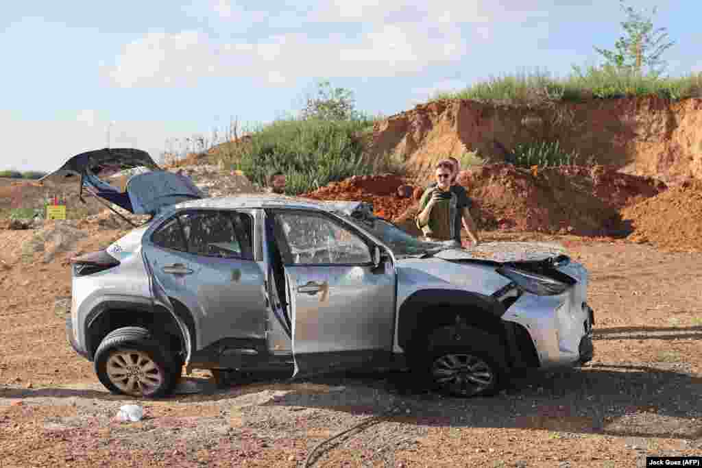 Men inspect a damaged car in Tel Aviv. The scale of the damage from the Iranian strikes remains unclear. One Palestinian man is known to have been killed by a falling section of rocket in the West Bank city of Jericho. 