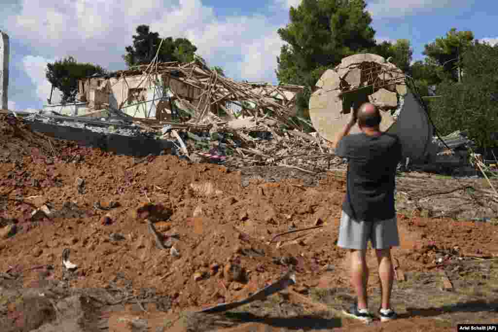A man photographs a building in Hod HaSharon, near Tel Aviv, that was destroyed in the October 1 attack. 
