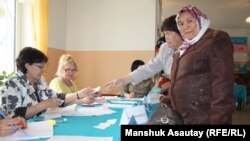 Члены избирательной комиссии и избиратели на участке в городе Каскелене в день досрочных президентских выборов. Алматинская область, 26 апреля 2015 года.