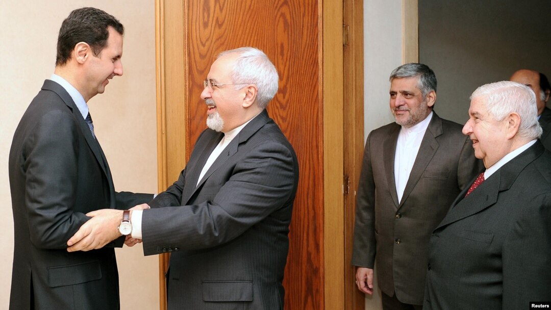 Syrian President Bashar al-Assad (left) welcomes Iranian Foreign Minister Mohammad Javad Zarif before a meeting in Damascus on January 15.