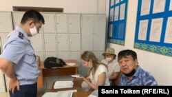 Активисты Жанат Нуркишев и Роза Мусаева, адвокат Ольга Эннс (в центре) в полицейском участке в Акмолинской области. 4 августа 2020 года.