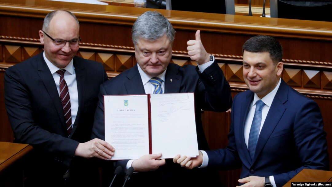 Зліва направо: спікер парламенту Андрій Парубій, президент Петро Порошенко і прем’єр-міністр Володимир Гроймсан на трибуні Верховної Ради з підписаним главою держави законом про зміни до Конституції, які закріплюють курс України на ЄС і НАТО. Київ, 19 лютого 2019 року