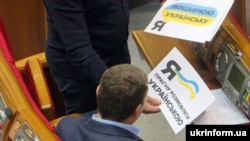 Один із депутатів у Верховній Раді в День української писемності та мови демонструє колезі листівки. Київ, 4 листопада 2016 року