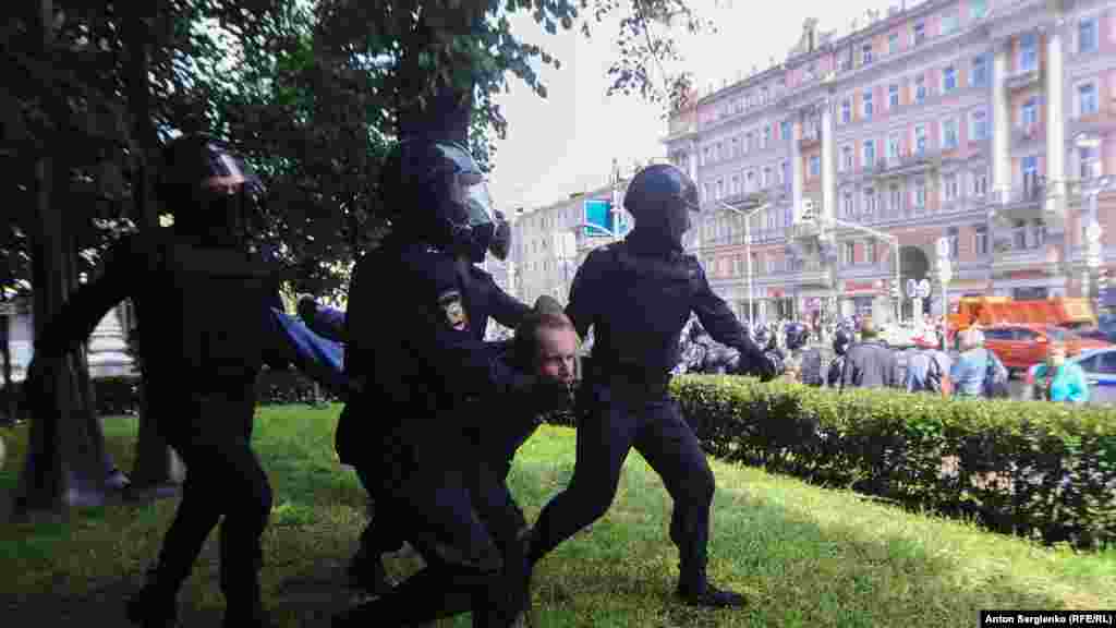 Шерушілерді ұстап бара жатқан полиция. 