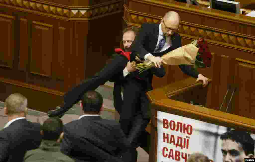 Депутат від «Блоку Петра Порошенка» Олег Барна виносить прем’єра Арсенія Яценюка з-за трибуни Верховної Ради. Після цього у залі зчинилася бійка. Київ, 11 грудня 2015 року