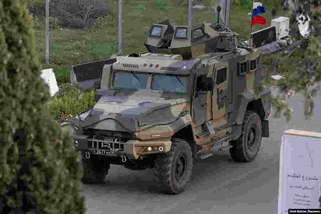 Un vehicul blindat rusesc se apropie de baza Hmeimim. „Să te poți afla acolo fără controale sau presiuni este o senzație ciudată”, spune Bektas. Fotograful și-a început activitatea la fața locului, informând mai întâi combatanții rebeli în legătură cu prezența sa acolo. „Dar dacă îți găsești o clădire mai înaltă, poți sta acolo ore în șir pentru a face poze, ceea ce era imposibil până recent”, mai spune fotoreporterul. 